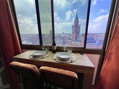 une table dans une pièce avec vue sur une ville dans l'établissement Studio Douce Brise, à Dunkerque