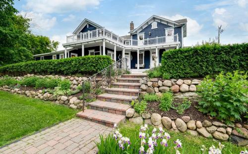 a large white house with a garden with flowers at The Guest House in Excelsior