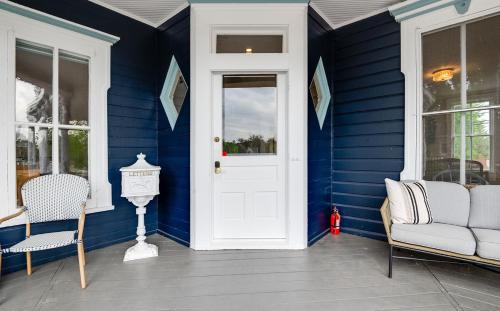 a blue house with a white door and chairs at The Guest House in Excelsior