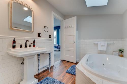 a white bathroom with a sink and a tub at The Guest House in Excelsior