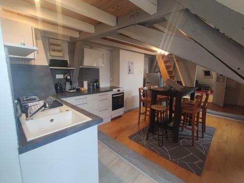 une cuisine avec un évier et une table avec des chaises dans l'établissement Hyper centre les martelos, à Besançon
