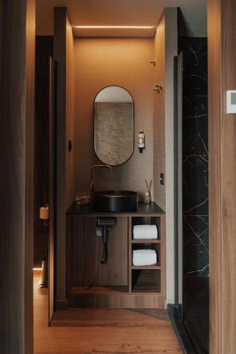 a bathroom with a sink and a mirror at Hotel Leiriartem by Grupo Quinta dos Lagos in Leiria