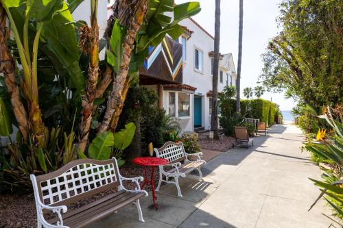two benches and a table on a sidewalk at Sea Blue Hotel in Los Angeles