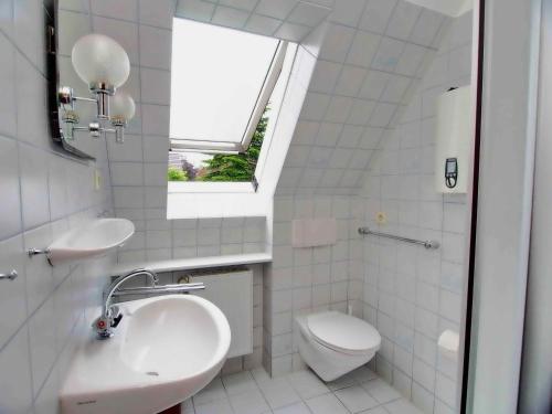 a bathroom with a sink and a toilet and a window at Gaestehaus-Bruhn-6 in Alkersum