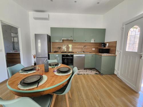 une grande cuisine avec une table et des chaises en bois dans l'établissement maison individuelle, à Tourrette-Levens