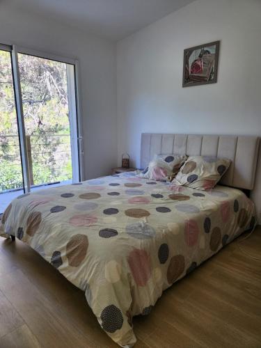 - un lit avec une couette en fleurs dans une chambre dans l'établissement maison individuelle, à Tourrette-Levens
