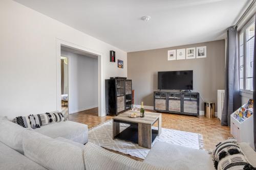 a living room with a couch and a tv at Alexandre et Charline in La Souterraine