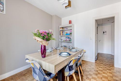 a dining room with a table with a vase of flowers at Alexandre et Charline in La Souterraine