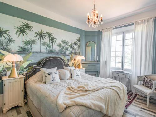 - une chambre avec un grand lit recouvert de palmiers dans l'établissement Charme, à Callian