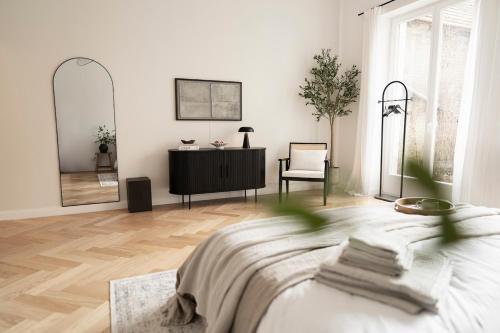 a bedroom with a bed and a dresser and a mirror at Design Apartment with Garden in Berlin