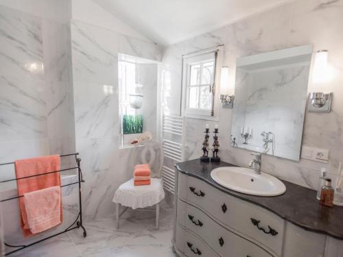 une salle de bain blanche avec un lavabo et un miroir dans l'établissement Charme, à Callian