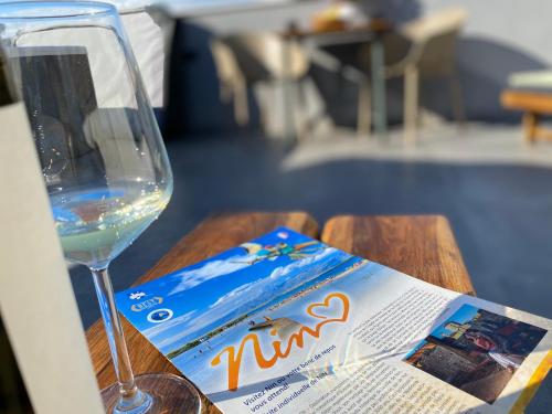 a glass of wine and a magazine on a table at Dalmatia Nin apartment in Nin