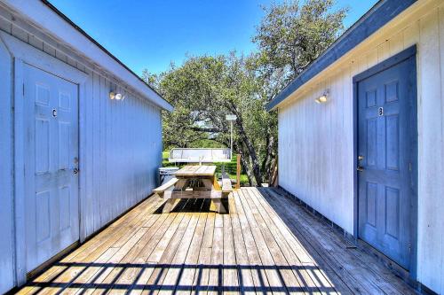 a deck with two blue doors and a picnic table at Fantasy Oaks Lodge in Aransas Pass