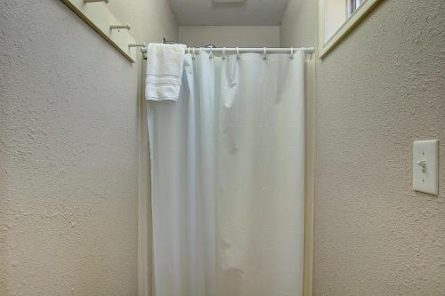 a bathroom with a shower with a white shower curtain at Fantasy Oaks Lodge in Aransas Pass