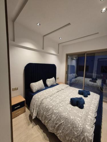 a bedroom with a large bed and a mirror at Seaside Escape - Modern Comfort and Relaxation in Mehdia in Kenitra