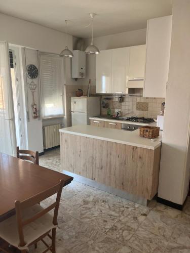 a kitchen with white cabinets and a wooden counter top at Casa di Rita - Appartamento nel centro di Riva Trigoso vicino alla spiaggia in Riva Trigoso
