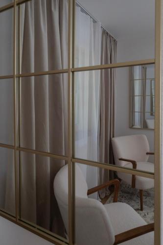 a living room with a mirror and a chair and a chair at Idyllische Ferienunterkunft in Aidling am Riegsee in Riegsee