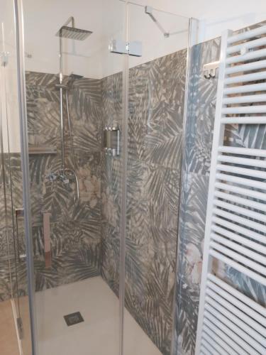 a bathroom with a shower with a design on the wall at Cascina Olmetto di Sotto in Ghedi