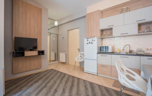 a kitchen with a white refrigerator and a table and chairs at Luxury House in Tbilisi City