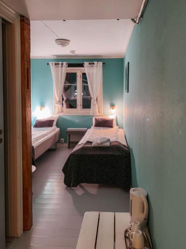 a bedroom with two beds and a bench in it at Finnholmen Brygge in Henningsvær