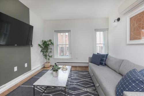 a living room with a couch and a tv at 304 Newbury Street by Thatch in Boston