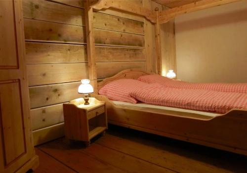 ein Schlafzimmer mit zwei Betten mit Holzwänden und Lampen in der Unterkunft Schwarzwaldbauernhaus Bernau in Bernau im Schwarzwald