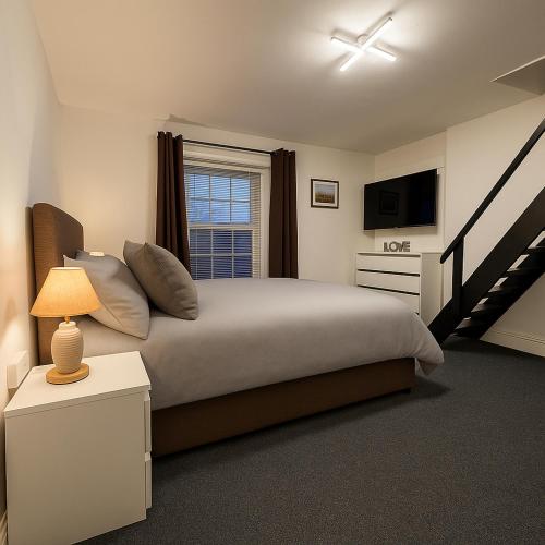 a bedroom with a large bed and a window at Great Georges Retreat Central Weymouth Beach Contactless Smart Accommodation in Weymouth