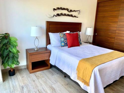 a bedroom with a bed with two lamps and a plant at Three New Beautiful Villas In Punta Cala in Nuevo Vallarta 