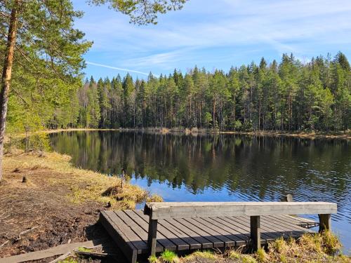 a wooden bench sitting on the shore of a lake at Stylish top floor ap, with private parking, next to a tram stop in Tampere