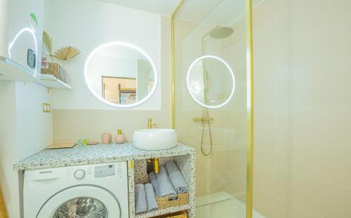une salle de bain avec une machine à laver et un lavabo dans l'établissement La Galinette, Vue mer, Climatisation, Fibre, à Saint-Cyr-sur-Mer