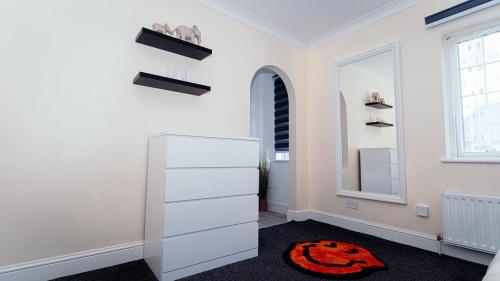 a room with a white dresser and a red rug at Modern, comfy 2 bedroom House in Hatfield, town centre, free parking, large garden in Hatfield