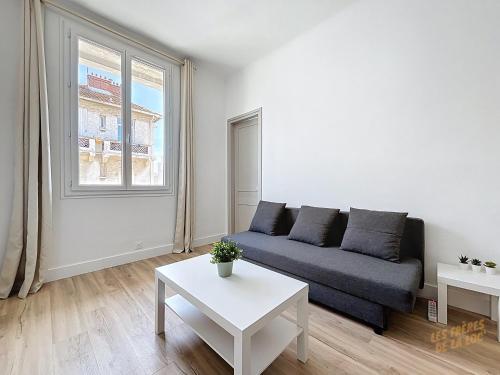 un salon avec un canapé et une table dans l'établissement Appartement proche des Plages et du Vélodrome - Les Frères de la Loc', à Marseille
