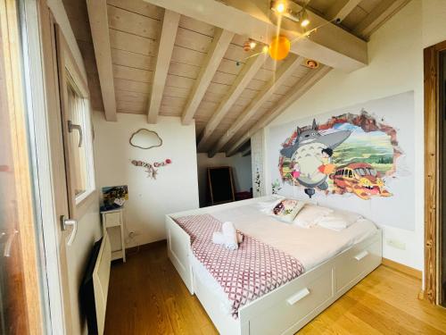 a bedroom with a bed with a painting on the wall at La Maison Magique! Magnifique chalet familial in Sallanches