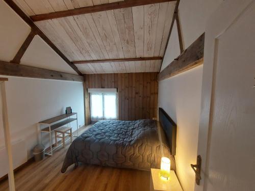 une chambre avec un lit et un bureau dans une pièce dans l'établissement Gite 12 personnes avec étang et piscine, à Saint-Hilaire-le-Vouhis