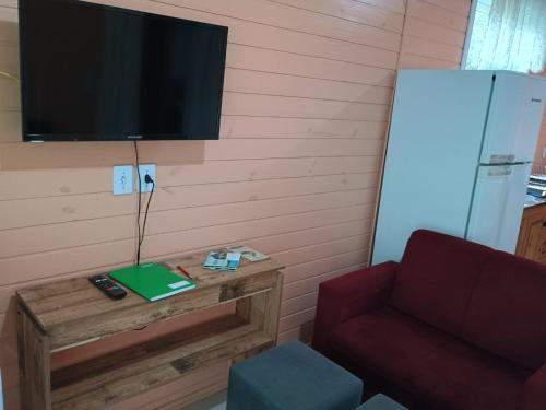 ein Wohnzimmer mit Couch und Flachbildfernseher in der Unterkunft Casa das Palmeiras in Rio Forcação