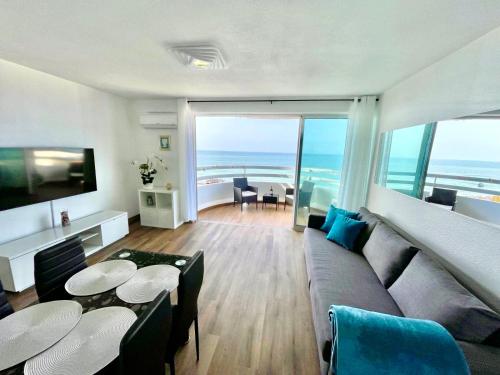 a living room with a couch and tables and a view of the ocean at Top Ocean View Apartment - amazing sunset - modern style - pool & 200m to beach in Portimão