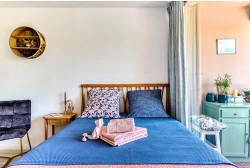 a bedroom with a blue bed with a doll on it at Studio Les Régates avec loggia et parking gratuit Plage du Grazel Gruissan in Gruissan