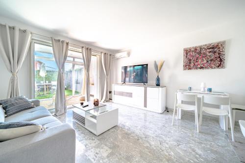 un salon blanc avec un canapé et une table dans l'établissement Studio Clim Piscine Nice ouest, à Nice