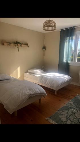 une chambre avec deux lits et un lustre dans l'établissement Gîte détente, à Petit-Berneval