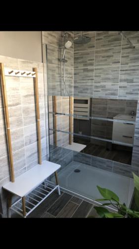 La salle de bains est pourvue d'une douche avec un banc et un lavabo. dans l'établissement Gîte détente, à Petit-Berneval