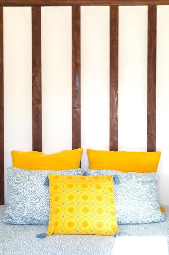two pillows on a bed with yellow and blue pillows at Beach House 1 in Labruge