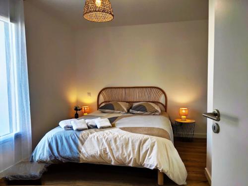 une chambre avec un lit avec deux serviettes dessus dans l'établissement Ker Phan Cozy urban cottage with hot tub, à Saint-Aubin-du-Cormier