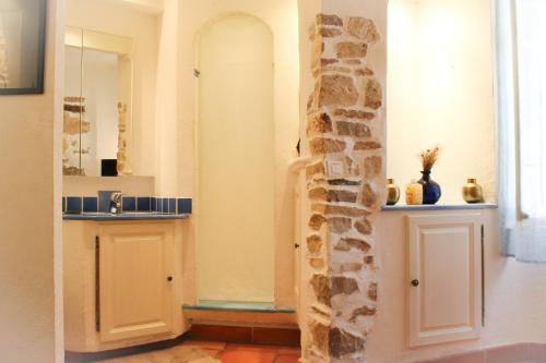 - une salle de bains avec un mur en pierre à côté d'un lavabo dans l'établissement La Tour du Vidourle, à Lecques