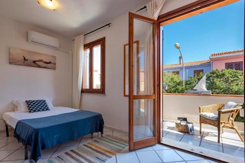 a bedroom with a bed and a sliding glass door at Sardinia Re - Casa Ginestra in Stintino