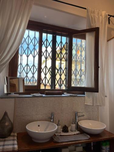 ein Badezimmer mit zwei Waschbecken und einem Fenster in der Unterkunft Cadorna in Florenz