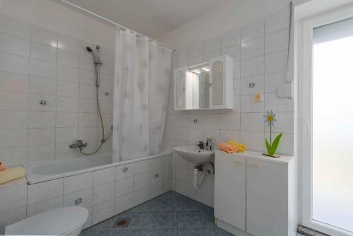 łazienka z umywalką, wanną i toaletą w obiekcie Holiday home in Porec/Istrien 10330 w Poreču