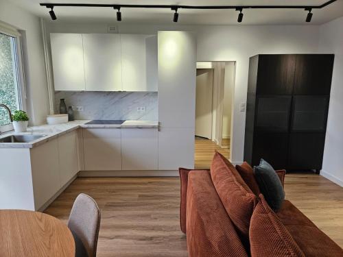 a living room with a couch and a kitchen at Cozy Nest Apartment in Świnoujście