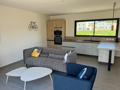 un salon avec un canapé et une cuisine dans l'établissement Villa cosy lina, à Gallargues-le-Montueux