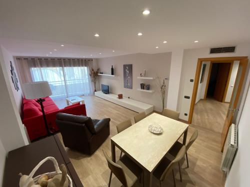 un soggiorno con un divano rosso e un tavolo di Piso céntrico reformado a Torredembarra