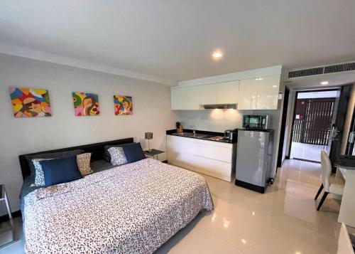 a bedroom with a bed and a kitchen with a refrigerator at Studio at Kris Condo walk to Bangtao beach 2304 in Bang Tao Beach
